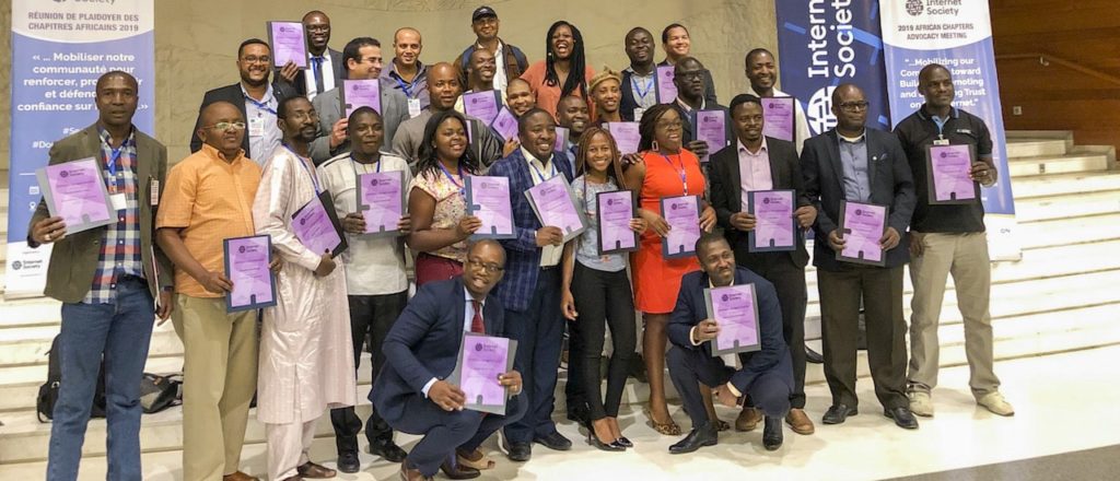 A group of people posing for a photo and holding a violet papers