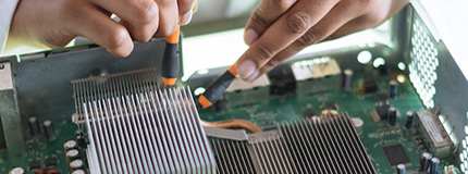 Crop technician checking contacts on motherboard in workshop