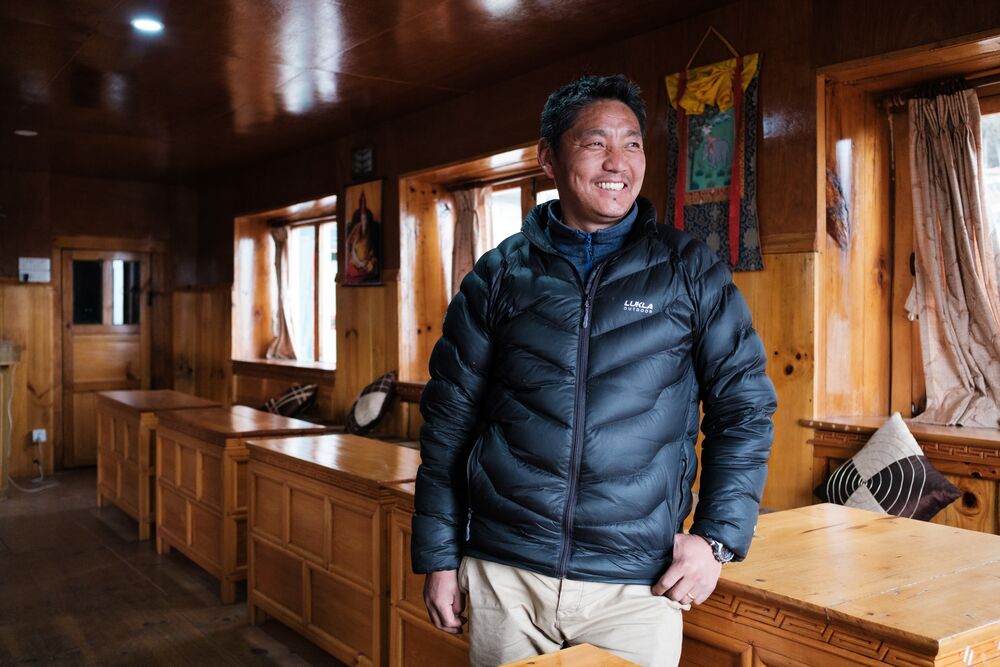 A man in winter jacket standing in the room and smiling