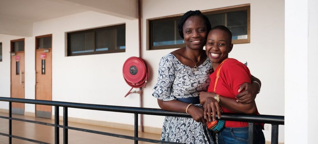 two women at a balcony hugged smiling